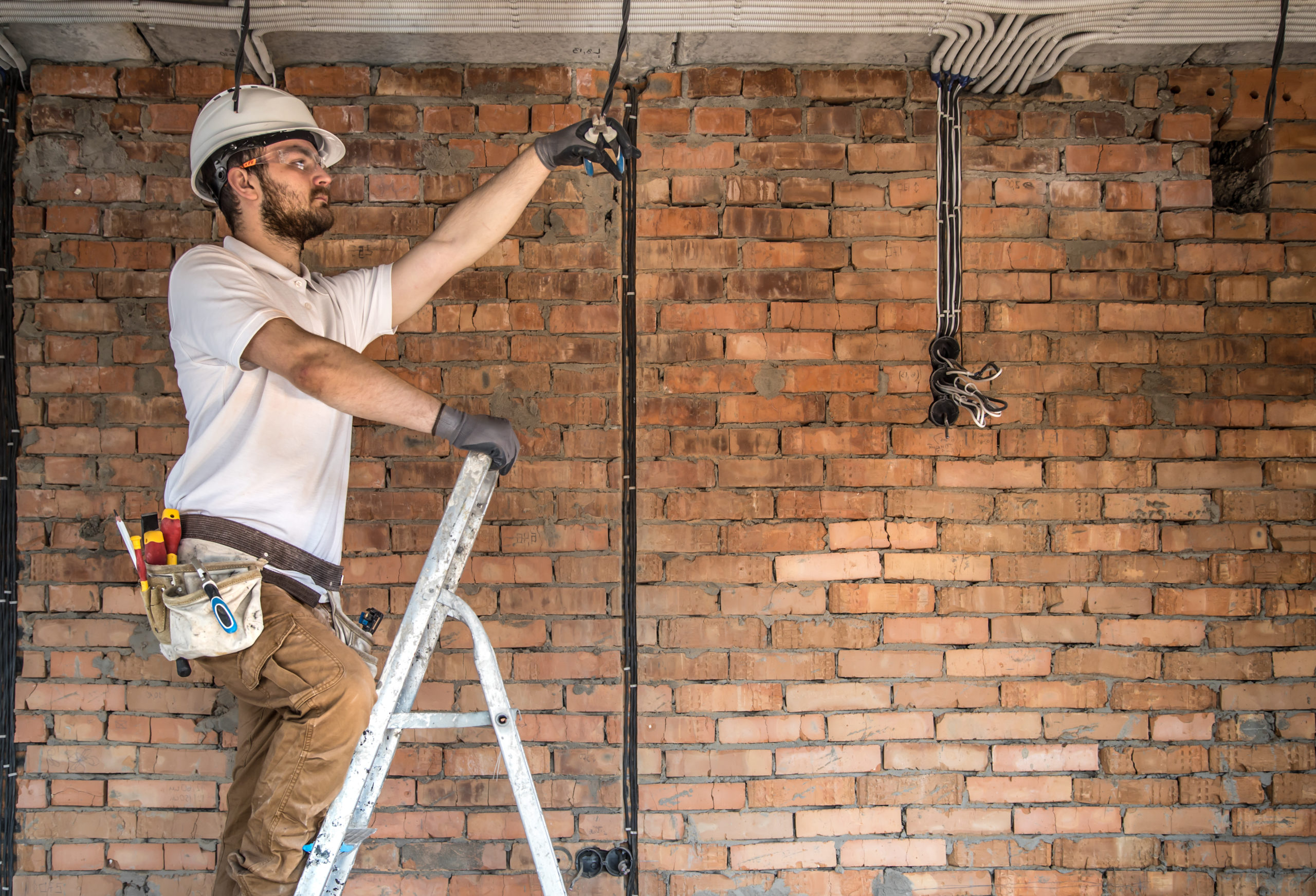 Électricien réalisant la rénovation complète d’une installation électrique dans une maison ancienne.